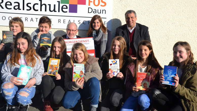 Das Foto zeigt Erwin Borsch vom Vorstand des Bürgerdienst e.V., Lehrerin Julia Pitzen, den stellvertretenden Schulleiter Thomas Follmann (rechts) und Leseratten der Realschule bei der Spendenübergabe.