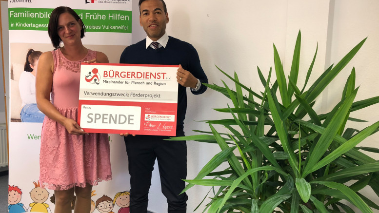 Spendenübergabe durch den Bürgerdienst e.V. für das Projekt FaBi-FrüHi-Kita Vulkaneifel. Denise Wagner-Schumann vom DRK nimmt den symbolischen Spendenscheck von Tyrone Winbush, Vorstandsmitglied Bürgerdienst e.V., entgegen.