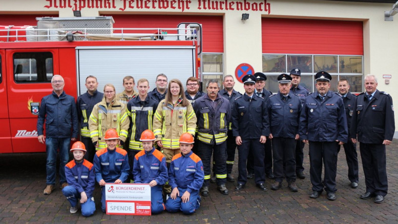 Unser Bild zeigt von rechts nach links: VG-Wehrleiter Karl-Heinz Kunze, stellv. VG Wehrleiter Uwe Mai, Wehrleiter der Feuerwehr Mürlenbach, Elmar Irsfeld, stellv. Wehrleiter Feuerwehr Mürlenbach Peter Mergen sowie, dahinter Christian Irsfeld, Leiter der Jugendfeuerwehr Mürlenbach, sowie Feuerwehrkameradinnen und Kameraden der Freiwilligen Feuerwehr und der Jugendfeuerwehr sowie ganz links, Werner Peters, Bürgerdienst e.V. sowie das neu angeschaffte Fahrzeug für die Jugendfeuerwehr Mürlenbach