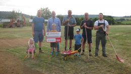 Symbolische Spendenübergabe auf dem Sportplatz in Duppach. Unser Foto zeigt: Links Thomas Jardin (2. Vorsitzender Sportverein Duppach); Zweiter von Links Werner Peters (3. Vorsitzender Bürgerdienst e.V.) und einige der vielen fleißigen Helfer