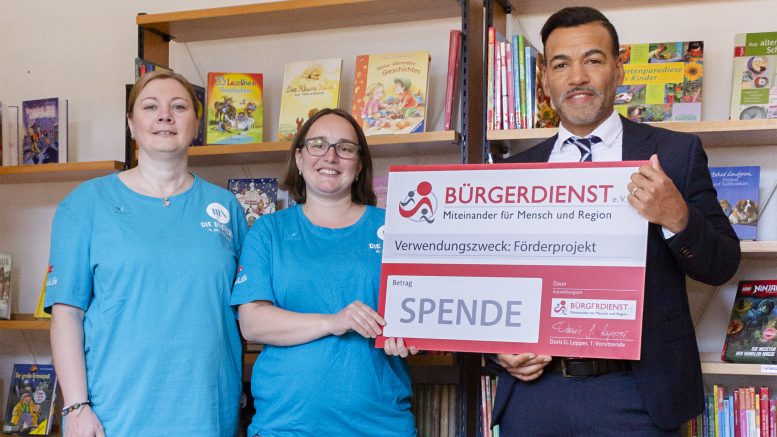 V.l.n.r.: Sandra Gitzen (Stv. Leitung Bücherei Darscheid), Katharina Holz (Leitung Bücherei Darscheid) mit Tyrone Winbush (BÜRGERDIENST e. V.)